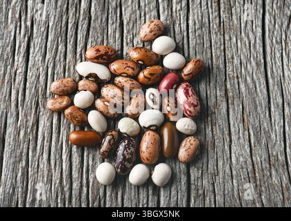 Blick von oben auf bunte Mischung getrockneter Hülsenfrüchte (Phaseolus vulgaris) auf rustikalem Holzhintergrund. Getrocknete Hülsenfrüchte für gesundes Kochen Konzept. Stockfoto