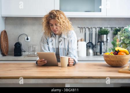 Einfaches Leben. Junge Frau Morgenroutine in der Hausküche in ihrer Wohnung mit dem ersten Kaffee, der aufwacht, bevor sie zur Arbeit geht. Lebensstil von s Stockfoto