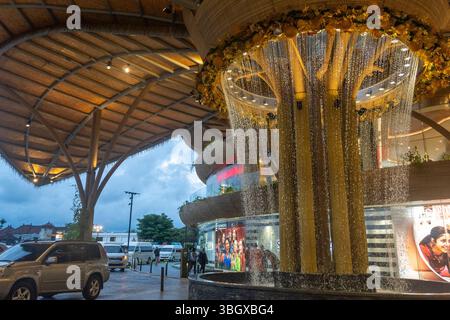 Bali, Indonesien - 17. Dezember 2024: Icon Bali Mall in Bali. Großer Baum mit einem Brunnen in der Mitte. Der Brunnen sprüht Wasser. Die Szene ist p Stockfoto