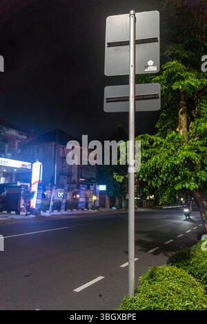 Bali, Indonesien - 17. Dezember 2024: Straßenschild von hinten. Das Schild steht auf einem Pfosten und ist von Bäumen umgeben Stockfoto