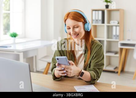 Glückliche Freelancerin, Die Zu Hause Online Mit Laptop Und Telefon Arbeitet Stockfoto