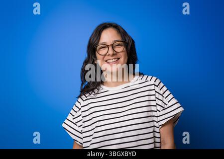Junge Erwachsene hispanische Frau in ihren 40ern mit Brille im Studio mit lässiger Kleidung. Konzept der Augenpflege und Sehpflege und Brille Stockfoto