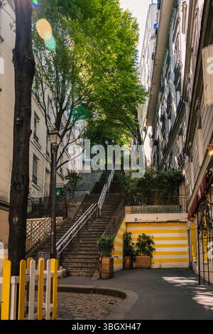 Ein wunderschöner und ruhiger Blick auf eine lange Treppe, die eine enge, von Bäumen gesäumte Straße in einer bezaubernden europäischen Stadt hinaufführt. Stockfoto