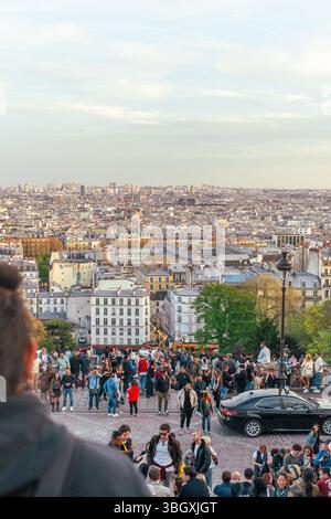 Eine große Menschenmenge versammelt sich am beliebten Aussichtspunkt in Montmartre, um an einem hellen Tag den atemberaubenden Panoramablick auf das Pariser Stadtbild zu genießen. Stockfoto