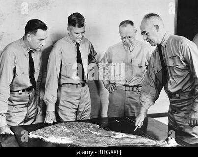 Veteranenbüros der US Army und des Marine Corps untersuchen das Modell einer Karte von Iwo Jima, als sie die Invasionspläne der Insel fertigstellten. Sie befinden sich von links nach rechts: Konteradmiral W. H. P. Blandy, Konteradmiral H. W. Hill, Generalleutnant Holland M. Smith und Vizeadmiral Richmond Kelly Turner. 26. Februar 1945 Stockfoto