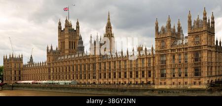 Panoramablick auf die Houses of Parliament an der Themse mit der Union Jack Flag, die stolz fliegt. Es wurde kürzlich renoviert und sieht frisch aus Stockfoto