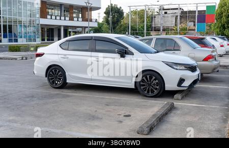 Weiße Sportlimousine mit Blick von der rechten Seite parkt auf dem offenen Parkplatz des Kaufhauses. Stockfoto