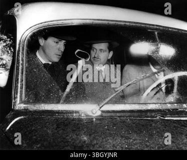 Sun sagte, er hätte Mutter mit Peitsche geschlagen. Der New Yorker Detective fragt Tibor Foldvary, 29, (mit Schnurrbart), etwa 4 Fuß lange Gaucho-Peitsche aus Rohleder (Handgriff oben), nachdem Foldvary Mutter, Dr. Mary Foldvary, 62, geschlagen und bewusstlos in ihrem Haus in Bronx aufgefunden wurde. 16. Februar 1957 Stockfoto