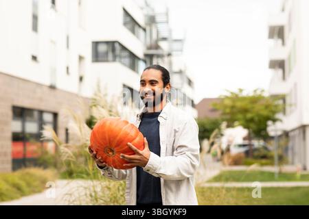 Junger Mann mit Kürbis in der Stadt Stockfoto
