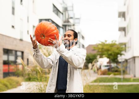 Junger Mann mit Kürbis in der Stadt Stockfoto