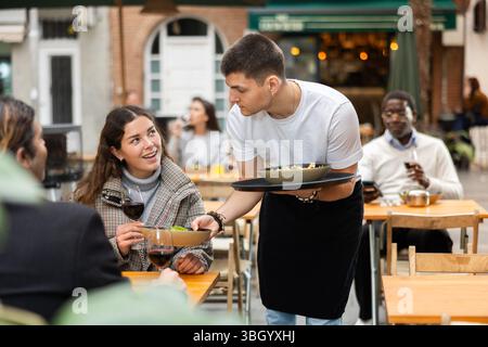 Der Kellner brachte eine fertige Bestellung in ein Restaurant Stockfoto