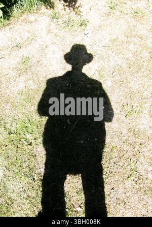 Schatten eines Mannes, der einen Hut mit Krempe trägt Stockfoto
