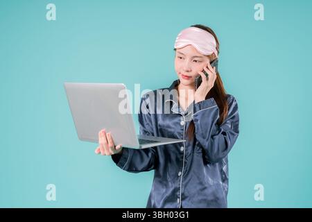 Asiatisch tragender Pyjama Unternehmer Notebook Social Lady, die online arbeitet, Eine junge Geschäftsfrau im lässigen Stil mit Laptop für Arbeit und Studium in einem Mod Stockfoto
