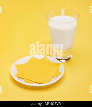 Käse und Milch fotografiert auf gelbem Hintergrund Stockfoto