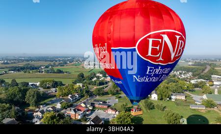 Ein lebhafter Heißluftballon schwebt über dem Ephrata-Nationalpark und zeigt die wunderschöne grüne Landschaft darunter. Bird in Hand, Pennsylvania, 13. September 2024 - Stockfoto