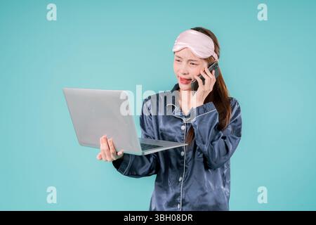 Asiatisch tragender Pyjama Unternehmer Notebook Social Lady, die online arbeitet, Eine junge Geschäftsfrau im lässigen Stil mit Laptop für Arbeit und Studium in einem Mod Stockfoto
