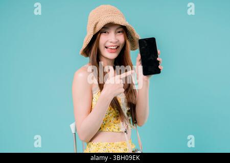 Asiatische Frau mit Smartphone für die Buchung und den Kauf von Tickets Online, Junge Frau, die ein Handy Sommerferienkonzept auf Studiohintergrund hält. Stockfoto