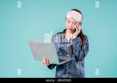 Asiatisch tragender Pyjama Unternehmer Notebook Social Lady, die online arbeitet, Eine junge Geschäftsfrau im lässigen Stil mit Laptop für Arbeit und Studium in einem Mod Stockfoto