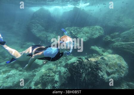 Junge Dame, die über Korallenriffen in einem tropischen Meer schnorchelt. Similan Inseln in Thailand, eine der Touristenattraktionen der Andamanensee Stockfoto