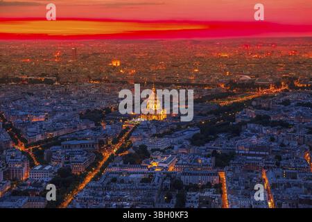 Blick aus der Vogelperspektive auf die Nationalresidenz des Invalidenpalastes bei rotem Sonnenuntergang mit Nachtlicht von der Panoramaterrasse der Tour Montparnasse. Paris urba Stockfoto