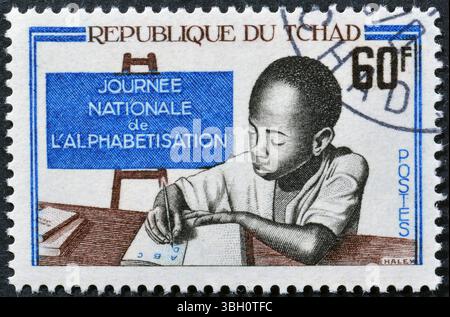 Von Tschad gedruckte Briefmarke mit dem Titel Child Writing, National Alphabacy Day, um 1968. Stockfoto