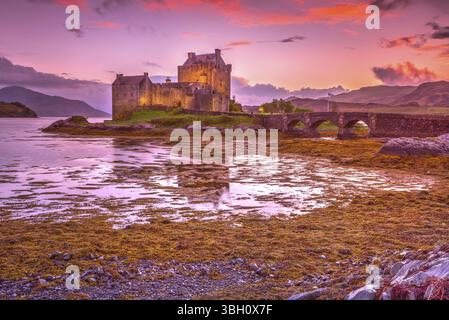 Magenta Sonnenuntergang am Eilean Donan Castle, Dornie, Kyle von Lochalsh in Schottland, Vereinigtes Königreich. Das meistbesuchte Schloss in Großbritannien. Auf einer Insel ein Stockfoto
