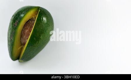 Avocadohälfte mit Grube auf weißer Oberfläche Stockfoto