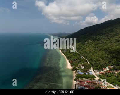 Grüne Küste mit einer gewundenen Straße, bewaldeten Hügeln und türkisfarbenem Wasser treffen auf Sandstrände. Ko Pha Ngan, Thailand. Stockfoto