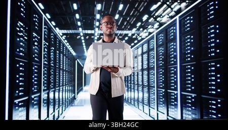 Lächelnder IT-Spezialist für die Konfiguration von Servern im Rechenzentrum. Professioneller Ingenieur. Stockfoto