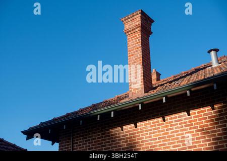 Ein altes Backsteingebäude mit einem Kamin, alte Industriebauten Stockfoto