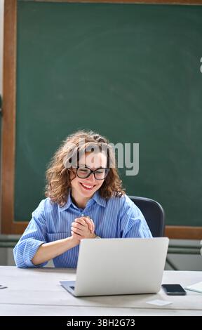Junge glückliche Geschäftsfrau, die sich aufgeregt fühlt, als sie einen Laptop ansieht, der gute Nachrichten liest. Stockfoto