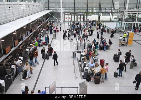 München, Deutschland. Juni 2025. Passagiere stehen an der Gepäckabfertigung im Terminal an. Der Flughafen München erwartet zu Beginn der Pfingstferien hunderttausende Passagiere. Quelle: Felix Hörhager/dpa/Alamy Live News Stockfoto