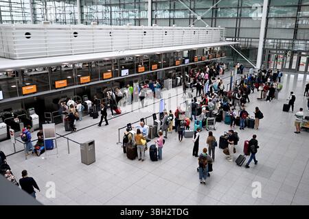 München, Deutschland. Juni 2025. Passagiere stehen an der Gepäckabfertigung im Terminal an. Der Flughafen München erwartet zu Beginn der Pfingstferien hunderttausende Passagiere. Quelle: Felix Hörhager/dpa/Alamy Live News Stockfoto