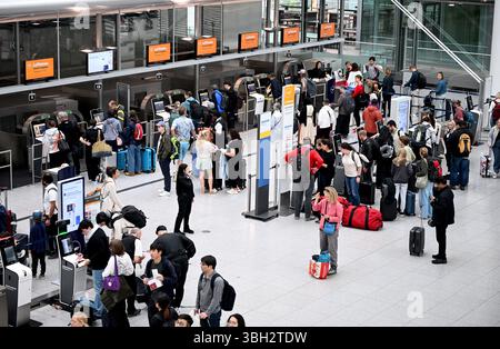München, Deutschland. Juni 2025. Passagiere stehen an der Gepäckabfertigung im Terminal an. Der Flughafen München erwartet zu Beginn der Pfingstferien hunderttausende Passagiere. Quelle: Felix Hörhager/dpa/Alamy Live News Stockfoto