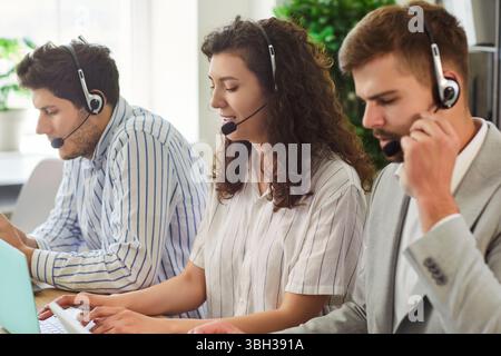 Selbstbewusste junge Geschäftsleute, die im Callcenter im Online-Support-Service-Büro arbeiten. Stockfoto