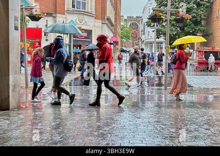 Exeter, Devon, Großbritannien. Juni 2025. Wetter in Großbritannien: Starker Regen in Exeter, Devon. Im Bild: Menschen mit Sonnenschirmen an einem regnerischen Tag im Zentrum von Exeter. Hinweis: Nidpor/Alamy Live News Stockfoto