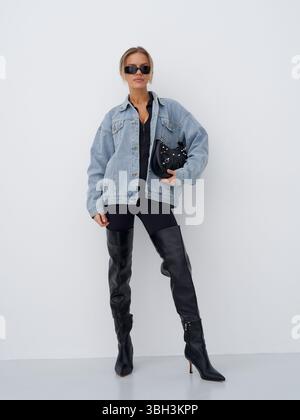 Modische Frau posiert stilvoll in lässigem Outfit während Fotoshootings in der Halle Stockfoto