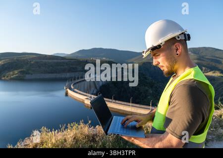 Techniker analysiert Daten auf einem Tablet in der Nähe einer Anlage für erneuerbare Energien Stockfoto