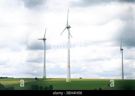 Lichtenau, Deutschland. Juni 2025. Drei Windräder stehen auf einer Wiese. Das Dorf mit seinen 1.750 Einwohnern verfolgt eine ehrgeizige Digitalisierungsstrategie: Glasfasernetzwerk ist überall verfügbar - freiwillig von der Dorfgemeinschaft angelegt. Es gibt eine Dorf-App, digitale Showcases, digitale Fahrgemeinschaften und ein elektrisches Dorfauto. Letztes Jahr erhielt Etteln den Smart City Award. Quelle: David Inderlied/dpa/Alamy Live News Stockfoto