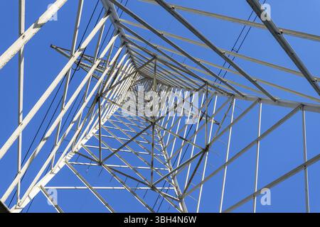 Hochspannungs-Stromnetz Pylon von unten und blauem Himmel gesehen Stockfoto