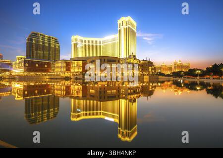 Malerisches Panorama der Stadt Macau, China, reflektiert auf dem See bei Sonnenuntergang. Urbane Nachtszene, Asien Stockfoto