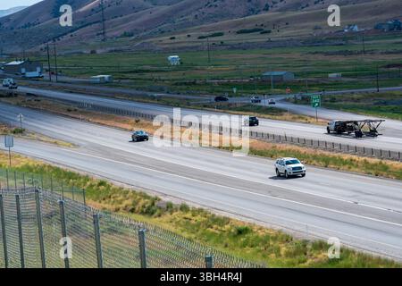 Santaquin, Utah – 8. Juni 2025: Tagsüber fahren mehrere Fahrzeuge auf der Interstate 15, die von oben gezeigt werden und den Verkehrsfluss und die Autobahn hervorheben. Stockfoto