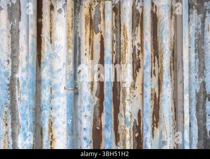 Alte gewellte Metallstruktur mit Rostflecken auf der Oberfläche und abgezogener Farbe Stockfoto