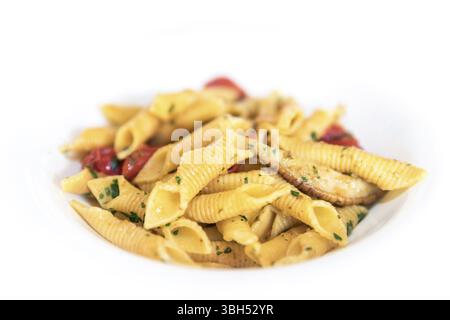 Rustikale italienische Penne-Pasta mit Pilzen, Kirschtomaten, Basilikum und Olivenöl. Nahaufnahme. Oberer Freiheitsgrad Kopierbereich Stockfoto