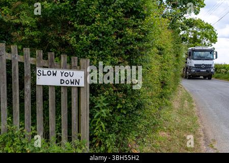 Verlangsamen Sie das handgeschriebene Straßenschild Stockfoto
