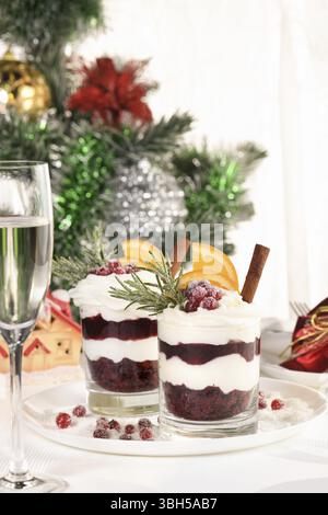 Weihnachts-Cranberry-Dessert-Tiramisu mit Mascarpone und Schlagsahne, Schokoladen-Kekskrümel und Cranberry-Marmelade, garniert mit Orangenscheiben, Dose Stockfoto