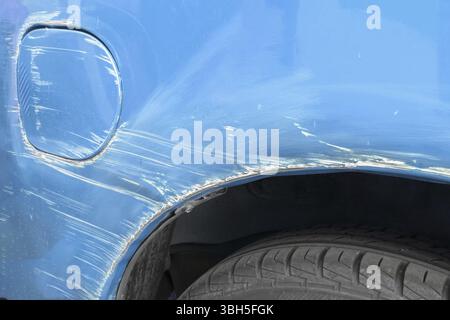 Kratzer an der Seite des roten Autos. Kollision oder Unfall Stockfoto