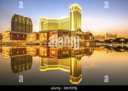 Spektakuläre goldene Skyline von Macau in China, die sich in der Dämmerung im Wasser spiegelt Stockfoto