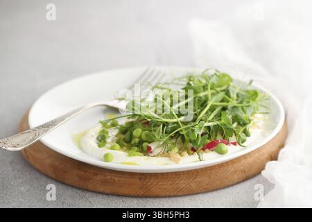Vegan gesunder Salat aus mikrogrünen Sprossen Erbsen, Quinoa, Rettich, Minze und Joghurt Stockfoto