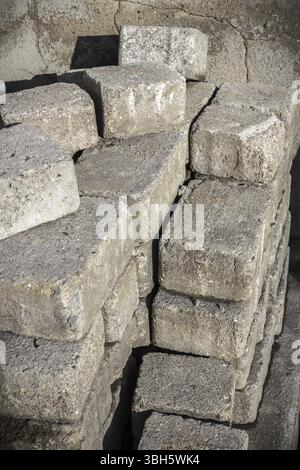 Stapel alter Pflastersteine, Betonblöcke für Pflastersteine. Straßenbausteine stapeln sich zur Umgestaltung Stockfoto